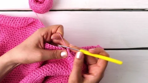 Top view of woman's hands crocheting with cotton yarn on white background Stock Footage 239746138