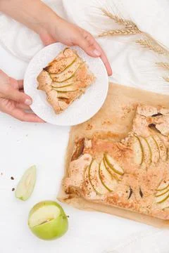Top view on woman's hands cutting homemade crispy apple pie. white textile an Stock Photos