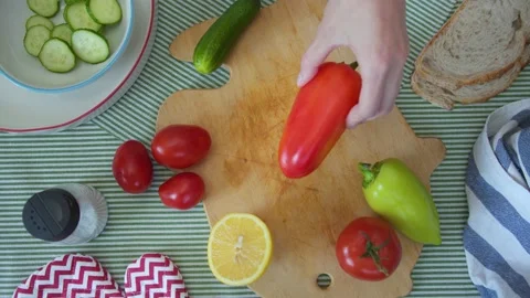 Top view of woman's hands slices sweet pepper with knife on cutting board with a Stock Footage 137825857