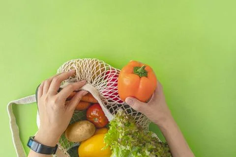 Top view of woman's hands taking vegetables out of eco-bag. tomatoes, cucum.. Stock Photos