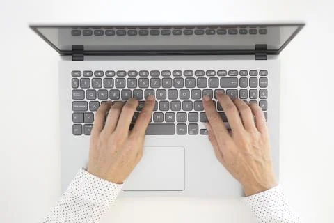 Top view of a woman's hands typing on a laptop computer. Stock Photos