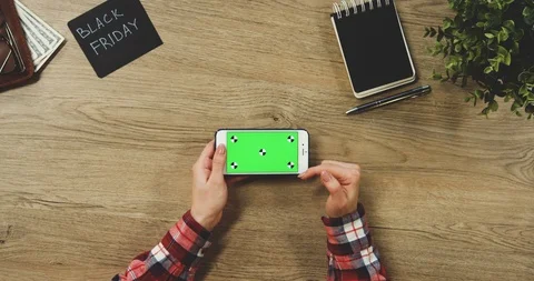 Top view on the woman's hands using the white horizontal smartphone with a green Video stock 89956229