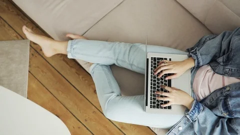 Top view of woman's hands working writing typing on laptop sitting on sofa. Stock Footage 127082953