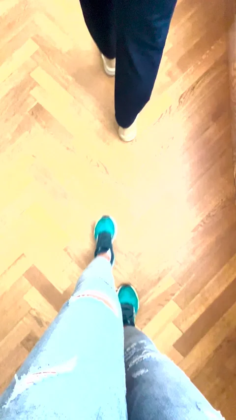 Top view of a woman's legs in blue jeans and sports shoes walking Stock Footage 273178311