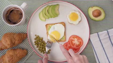 Top view women's hands cut toast with avocado and egg. Home morning breakfast Stock Footage 138079441