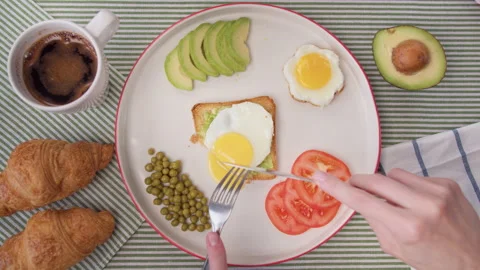 Top view women's hands cut toast with egg. Cute home breakfast, toasted toast Video stock 138234582