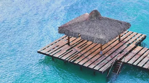 Top view of a wooden jetty over open water. Texture of blue clear sea water. Vidéo 252159914