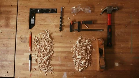 Top view of woodworking tools arranged on wooden workbench with wood shavings Stock Footage 340601436