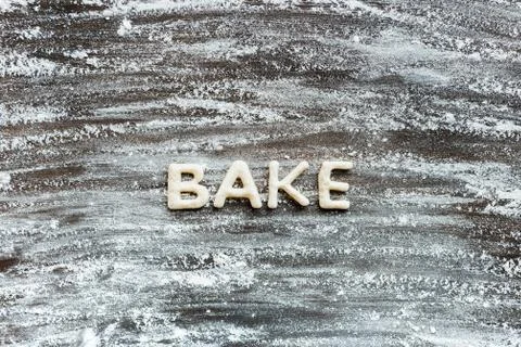 Top view of word bake made from cookie dough with flour on wooden surface Foto stock