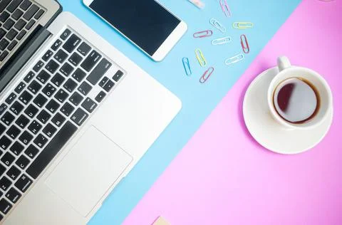 Top view of work desk.Laptop with notebook ,coffee,smartphone on colorful min Stock Photos