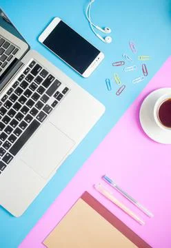 Top view of work desk.Laptop with notebook ,coffee,smartphone on colorful min Stock Photos
