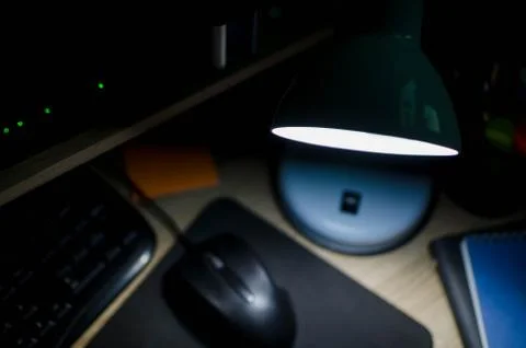 Top view on work office at night with dark view and white lamp light on desktop Stock Photos