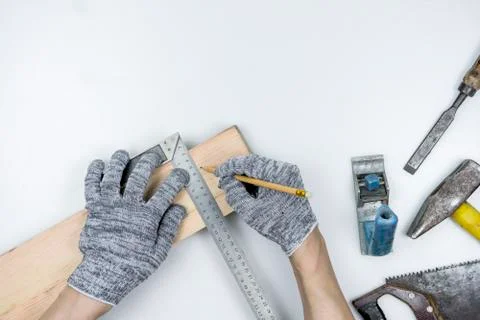 Top view of a work table in a carpentry workshop. Hands in gloves hold a corner Stock Photos