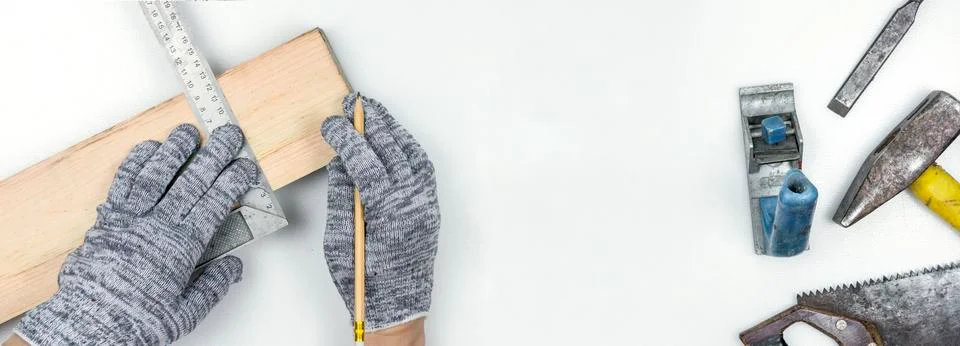 Top view of a work table in a carpentry workshop. Hands in gloves hold a corner Stock Photos