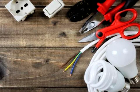 Top view of work tools and electrical system components on wooden background Stock Photos
