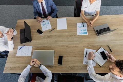 Top view work workplace. A team of young office workers, businessmen with laptop Stock Photos
