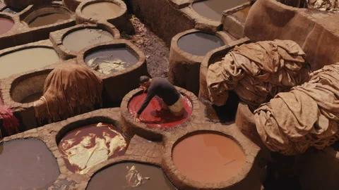 Top view of worker Soaking leather into the red Dye Pool Stock Footage 271307155