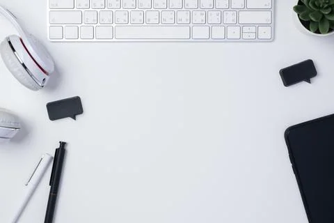Top view working desk with keyboard headphone and mobile phone on white tab.. Stock Photos