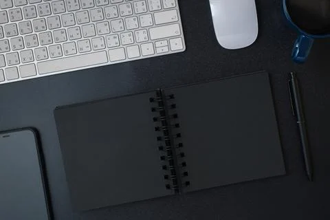 Top view working desk with keyboard headphone and open notebook on black ta.. Stock Photos