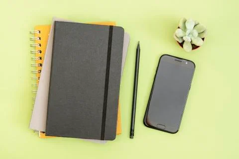 Top view of working table. black closed notebook, coffee cup and smartphone.  Stock Photos