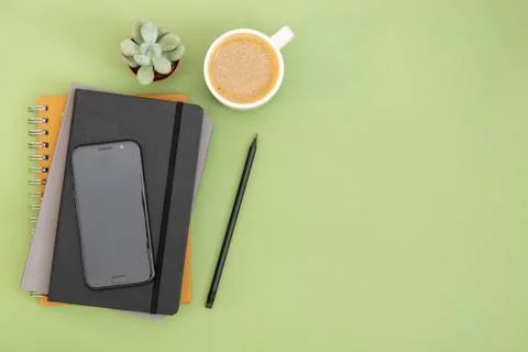 Top view of working table. black closed notebook, coffee cup and smartphone.  Stock-Fotos