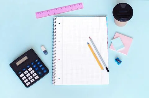 Top view of the workplace with notebook pen and calculator on a blue background Stock Photos