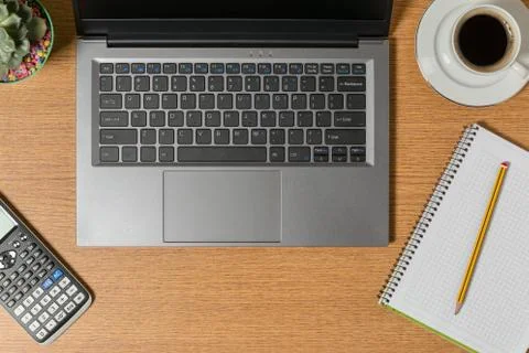 Top view of a workspace with a laptop a notepad with a pencil and a cup of co Stock Photos
