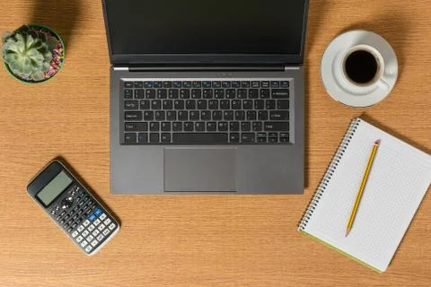 Top view of a workspace with a laptop a notepad with a pencil and a cup of co Photos