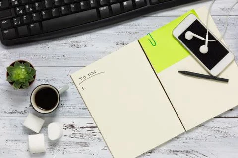 Top view of a workspace with open empty notebook. Stock Photos