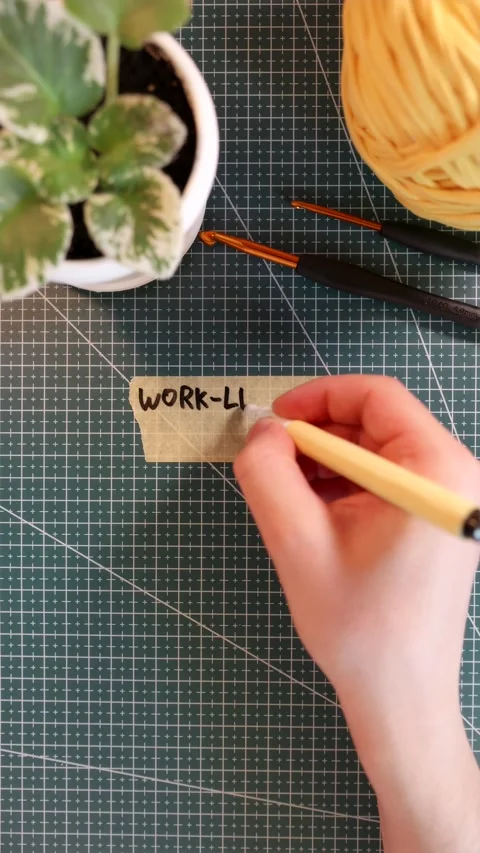 Top view of writing WORK-LIFE BALANCE on tape near knitting yarn and plant Stock Footage 338183675