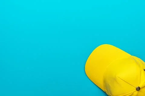 Top view of yellow baseball cap over blue turquoise background with copy space Stock Photos