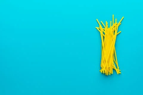 Top view of yellow drinking straws over turquoise blue background and copy space Stock Photos