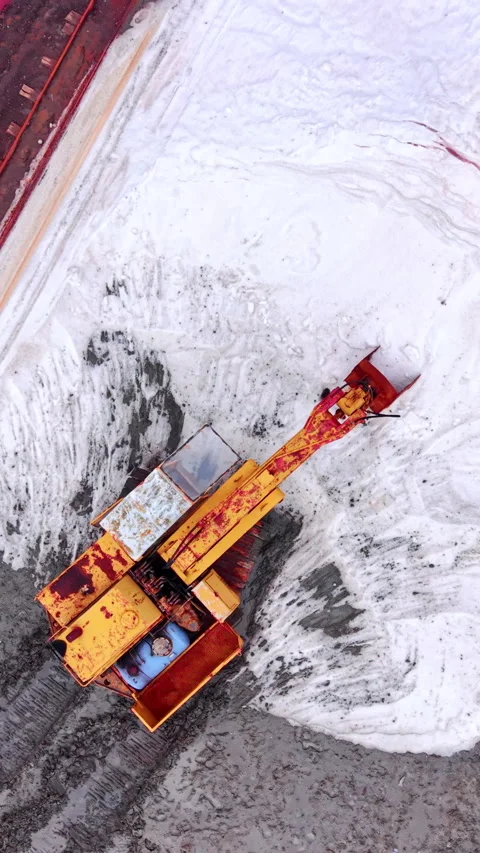 Top view of yellow excavator on white salt surface Vertical video. Stock Footage 332344918