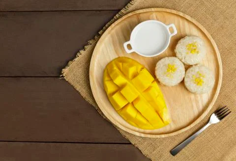 Top view Yellow half  mango with small fork. Mango fruit cubes on the wooden  Stock Photos