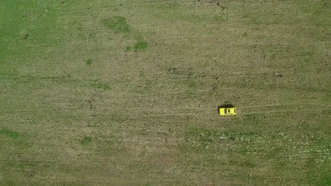 Top view of a yellow retro car ride through the green spring meadow Stock-Footage 237993444