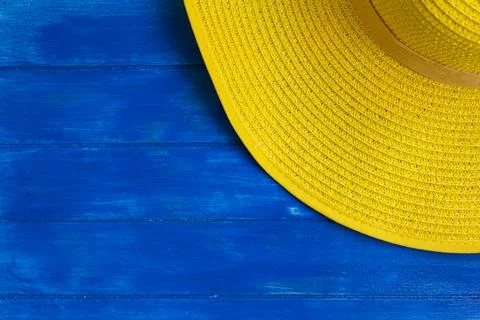 Top view of yellow summer hat on blue wooden background with copy space Stock Photos
