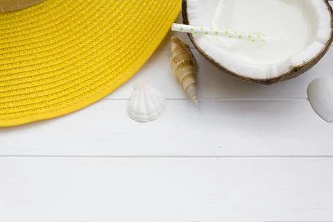 Top view of yellow summer hat and coconut water on white wooden table with co Stock Photos