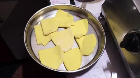 Top view of yellow sweet dough diamonds placed on steel plate on counter. Vídeo Stock 346116856