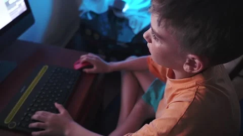 Top view of a young boy is intensely playing online computer video games at Stock Footage 279127964