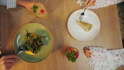 Top View of Young couple dining in a restaurant against a backdrop of green  Stock Footage 202478274