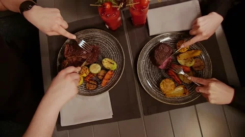 Top View young couple having dinner sitting at table in restaurant.Meat and Stock Footage 208631783