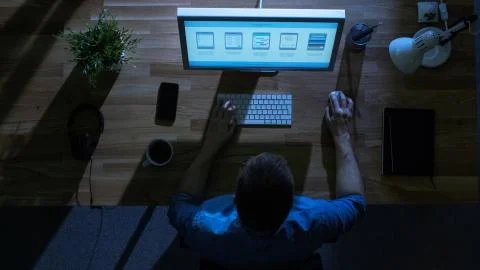 Top View of Young Creative Designer Working at His Desktop Computer at Night. Stock Photos