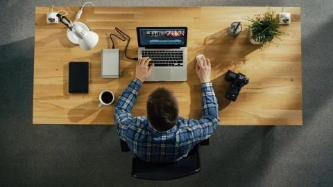 Top View of Young Creative Man Working on His Laptop Beside Him on the Table  Stock Photos