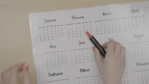 Top view of a young female hands with red nails marking dates on calendar pla Stock Footage 87017652
