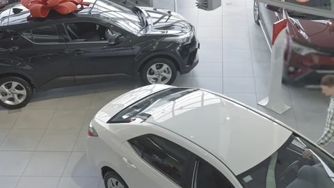 The top view of a young, happy man who is approaching a luxury car in the Stock Footage 101111959