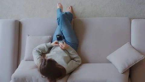 Top view. Young lady holding a smartphone, using mobile apps. Stock Footage 233377227