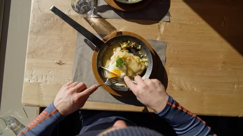 Top view of young man in beanie having lunch, apres ski, Swiss Alps Stock Footage 129087734