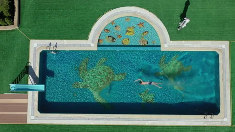 Top view of young man jumping in pool and splashing crystal clear water Stock Footage 143991281