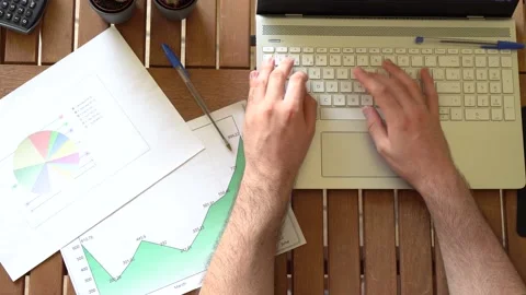 Top view of young man sitting at table typing on a laptop during work remotel Stock Footage 162560965