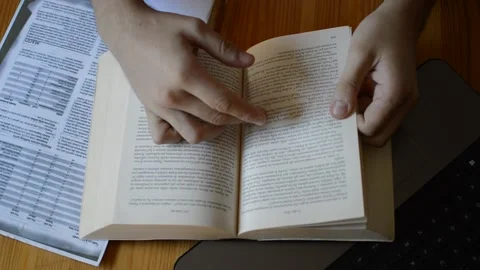 Top view young man's hand study on a literature book for university exams. Vidéo 205854539